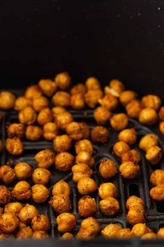 roasted chickpeas are being cooked in an air fryer with oil on the side