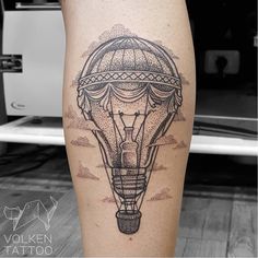 a black and white photo of a hot air balloon tattoo on the right calf leg