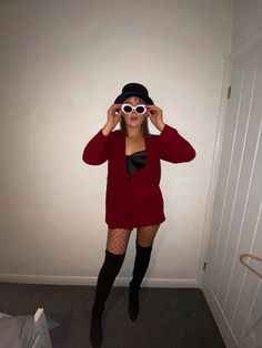 a woman wearing fishnet stockings and thigh high socks is holding up her glasses in front of her face