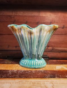 a blue vase sitting on top of a wooden table