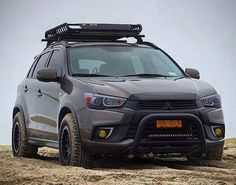 the front end of a silver car with a black roof rack