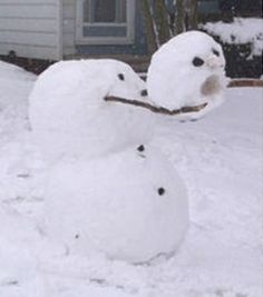 a snowman made to look like it is standing in the snow with his nose open