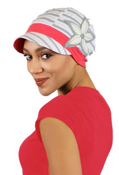 a woman wearing a red top with a white flower on it's brim