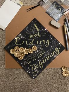 a graduation cap that has been decorated with gold and black lettering on it, surrounded by other items