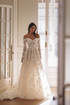 a woman in a wedding dress is standing by the door