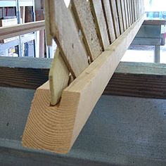 a wooden bench sitting on top of a cement floor next to a window sill