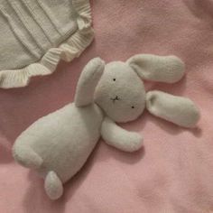 a stuffed animal laying on top of a pink blanket