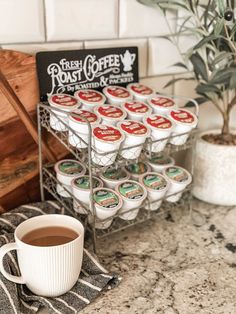 a cup of coffee sitting on top of a counter next to a rack with cups