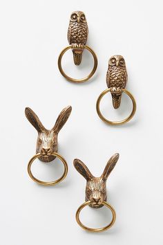 three brass rings with animals on them and one has an owl, the other is a rabbit