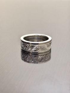 a wedding band with an intricate design on the outside and inside, sitting on top of a table