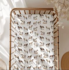 a baby crib with horses printed on it