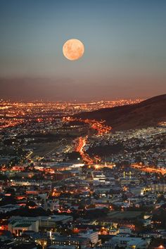 the full moon is seen over a city at night in this view from an airplane