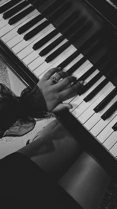 a person sitting at a piano with their hands on the keys