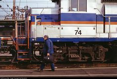 a man walking next to a train on the tracks