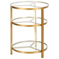 a round glass table with gold trimmings and two shelves on the bottom shelf