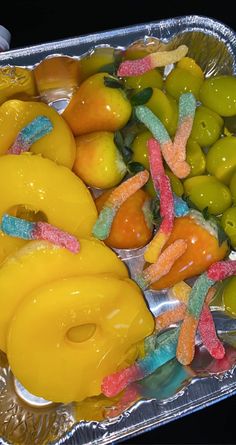 there are many different types of candies in the tin foil tray on the table