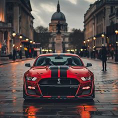 a red and black car parked on the street