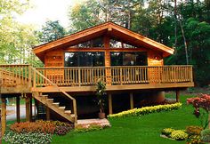 a large wooden house sitting on top of a lush green field