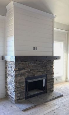 an empty room with a stone fireplace in it