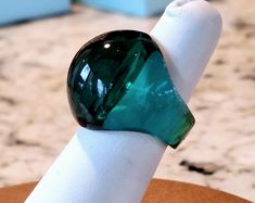 a green ring sitting on top of a white napkin dispenser in front of a counter