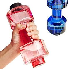 a hand holding a pink and blue glass bottle next to another one with a black top