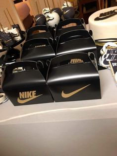 several black boxes with nike logos on them are sitting on a table in front of a cake