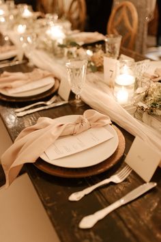 the table is set with place settings, candles and napkins for dinner guests to enjoy