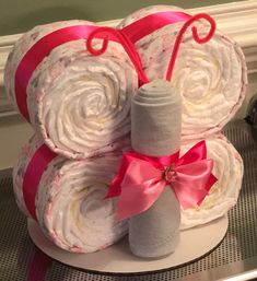 the diaper cake is made to look like it has been rolled up and wrapped in pink ribbon