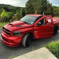 a red truck is parked on the side of the road