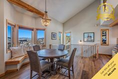 a dining room table and chairs in front of a window with a view of the city