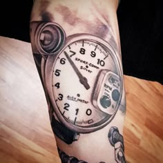 a clock tattoo on the arm and leg