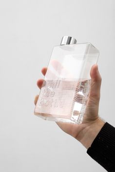 a person is holding a clear bottle in their hand