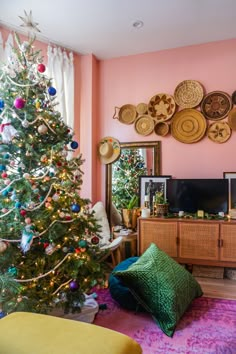 a living room with a christmas tree in the corner and many plates on the wall