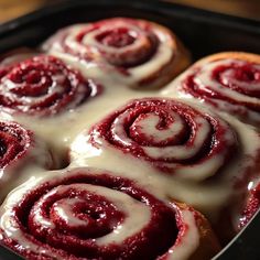 a pan filled with cinnamon rolls covered in icing