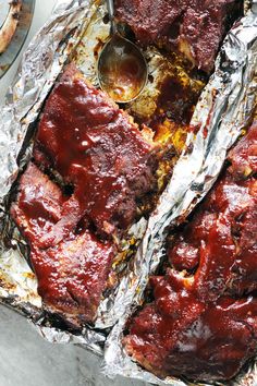 meatloaf covered in marinara sauce on top of tin foil with spoons