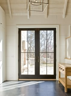 an empty entryway with double doors and windows