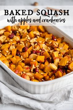 baked squash with apples and cranberries in a baking dish on a white towel