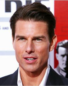 a close up of a person wearing a suit and white shirt at a red carpet event