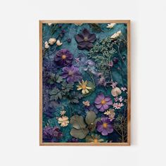 an art piece with purple flowers and green leaves on a white wall in front of a wooden frame