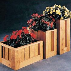 three wooden planters with flowers in them