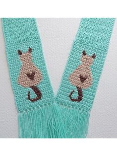 two crocheted scarfs with animals on them, one blue and the other green