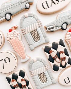 decorated cookies with cars and ice creams are on a white tablecloth that says class