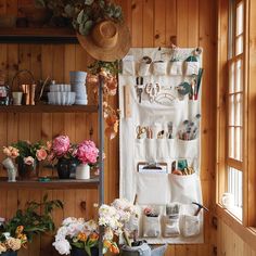 a room filled with lots of pots and flowers next to a wall covered in shelves