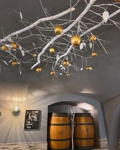 a room that has some wine barrels on the floor and decorations hanging from the ceiling