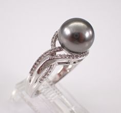 14K White Gold Diamond and Black Pearl Engagement Ring. This ring is set in the center with one Black Tahitian Pearl. This Pearl measures 9.5 mm in diameter. There are also seventy-two genuine Round Brilliant Diamonds set in this ring. These Diamonds are H color, I1 clarity and weigh a total of .25 carat. This ring is 14KT White Gold, weighs 5.2 grams and is a finger size 7, can be resized (please inquire about sizing with the finger size that you need). This ring is also accompanied by an appraisal written by a GIA Certified Diamond Grader with the retail replacement value of $1,785.00. I will ship this ring promptly in a beautiful gift box. ADDITIONAL REQUESTS If you would like to see more pictures of this item, please let us know and we would be happy to provide them for you. Please con Black Pearl Engagement Ring, June Gemstone, Tahitian Black Pearls, Pearl And Diamond Ring, Tahitian Pearls, Gia Certified Diamonds, Black Pearl, Tahiti