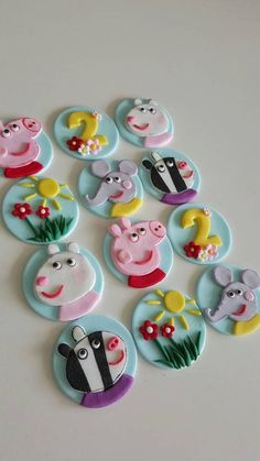 a bunch of buttons that are on a white surface with flowers and animals in them