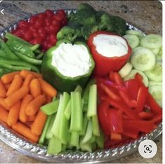 a bowl filled with veggies and dip on top of a table