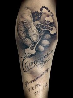 a tattoo on the leg of a person with a rosary and hand holding a cross