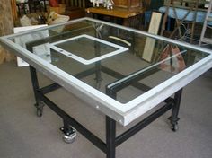 a glass table with metal frame and wheels