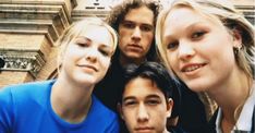 a group of young people standing next to each other in front of a tall building